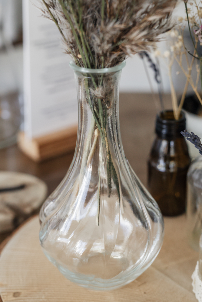 Dekration eines Tisches für eine Hochzeit mit Gläsern und Vasen